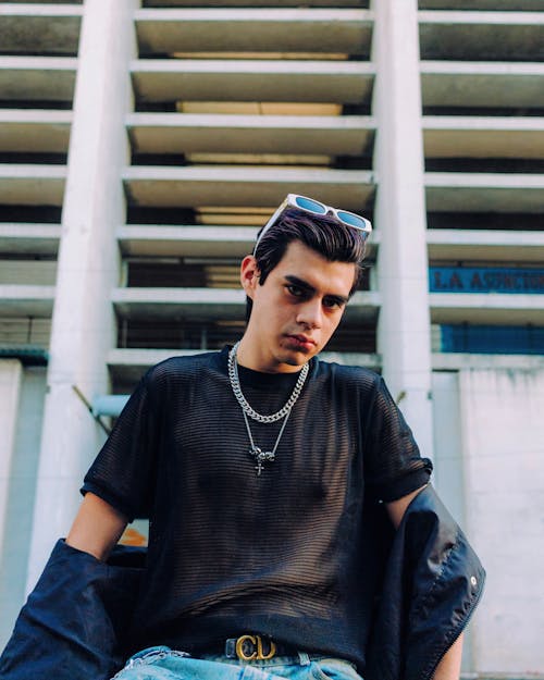 Man in T-shirt and with Necklaces Posing