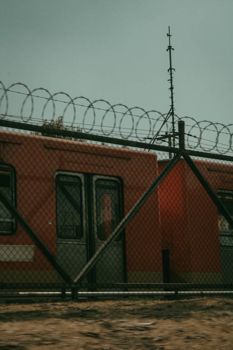 Train Passing Behind Barbed Wire Fence