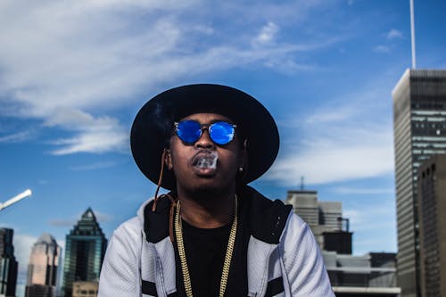 Photo of Man in Black Hat and Sunglasses Smoking