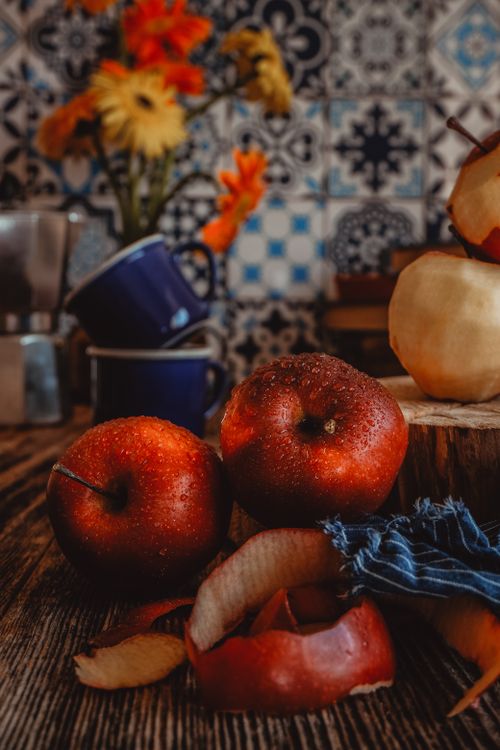 Free Close-up of fresh red apples with peeled skins in a cozy kitchen setting. Stock Photo