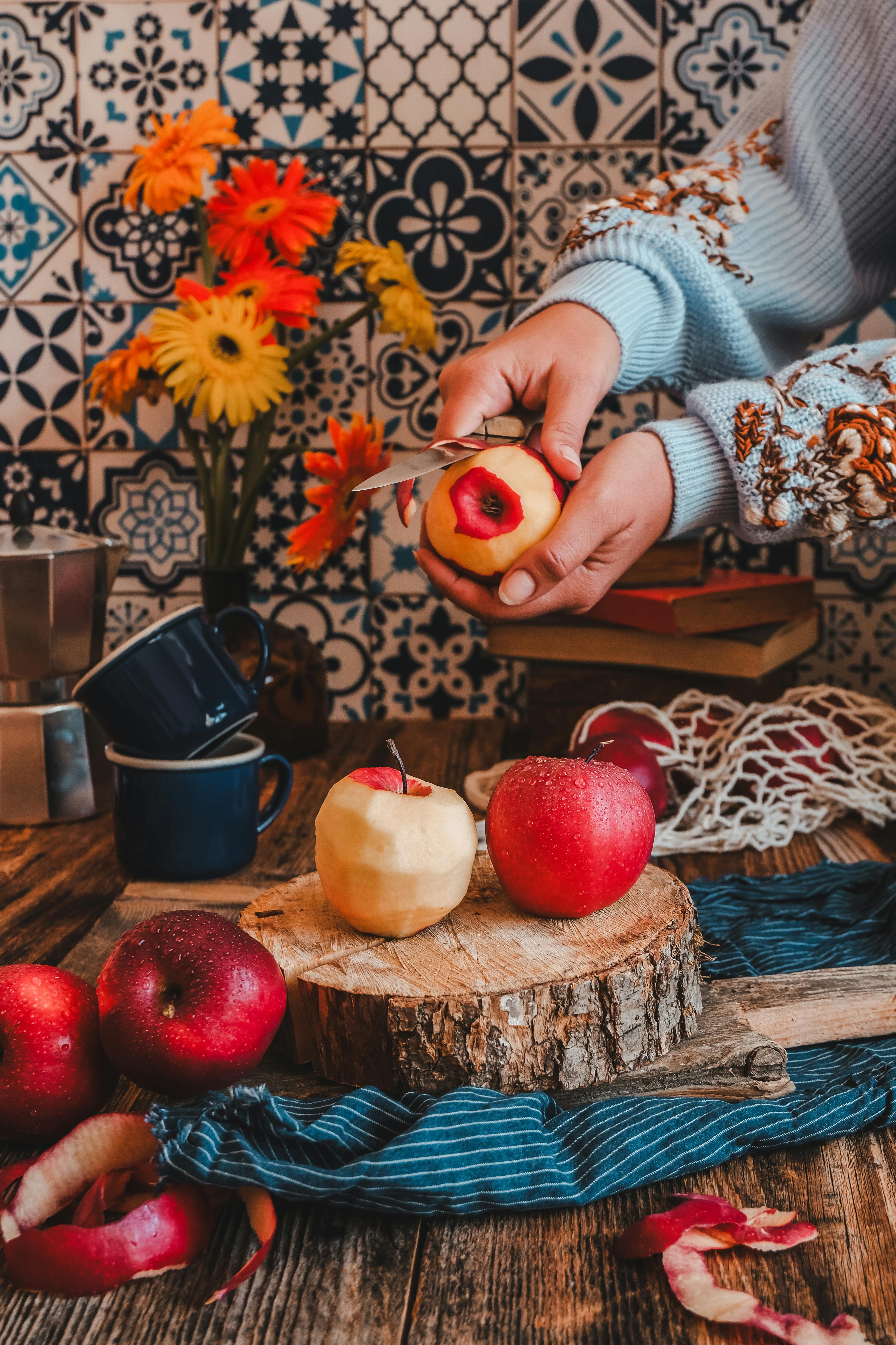 Warm kitchen setting with apples and flowers on a rustic table.