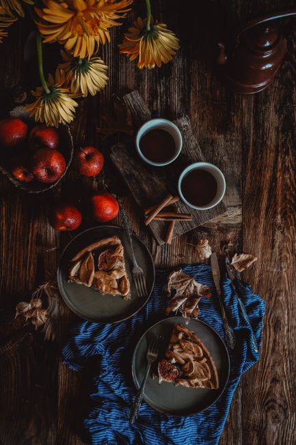 Warm autumn themed flat lay with apple pie, coffee, and flowers.