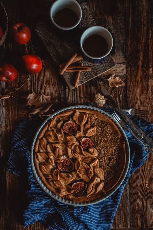 Free Delicious homemade apple pie with rustic autumn decor and red apples on a wooden table. Stock Photo