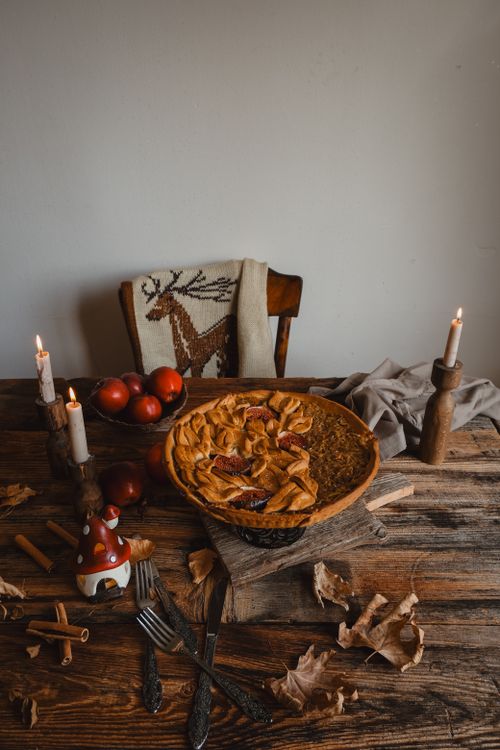Free Warm rustic autumn table setting with apple pie, candles, and cozy decor. Stock Photo
