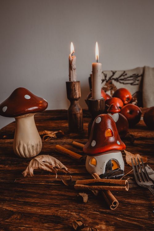 Free Charming fall-themed table setup with candles and mushroom decorations on a wooden surface. Stock Photo