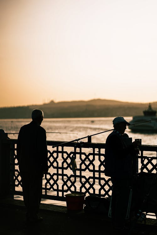 Silhouettes of Fishermen on a Bridge