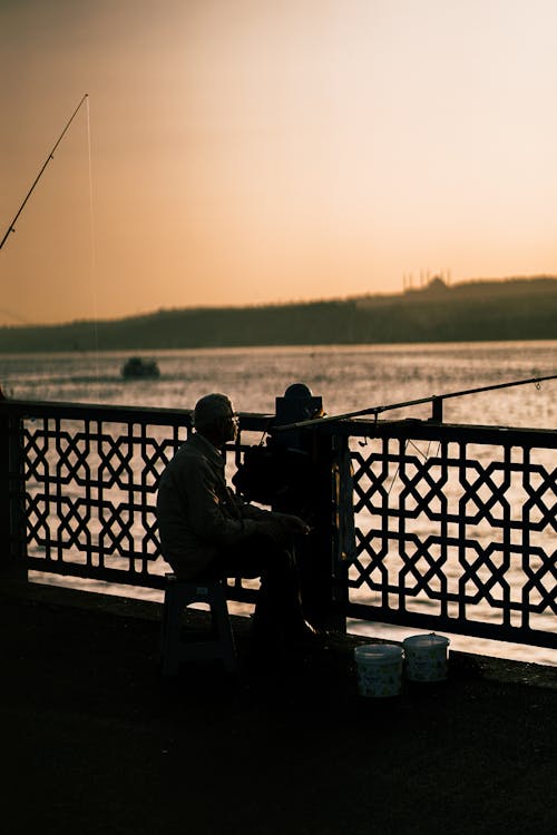 Silhouettes of Fishermen on a Bridge