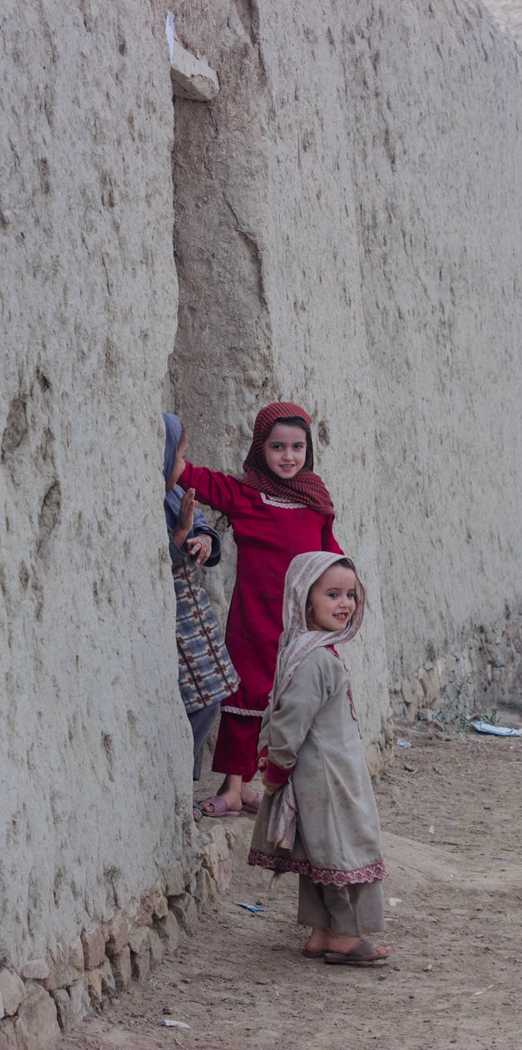 Smiling Girls Standing By Wall