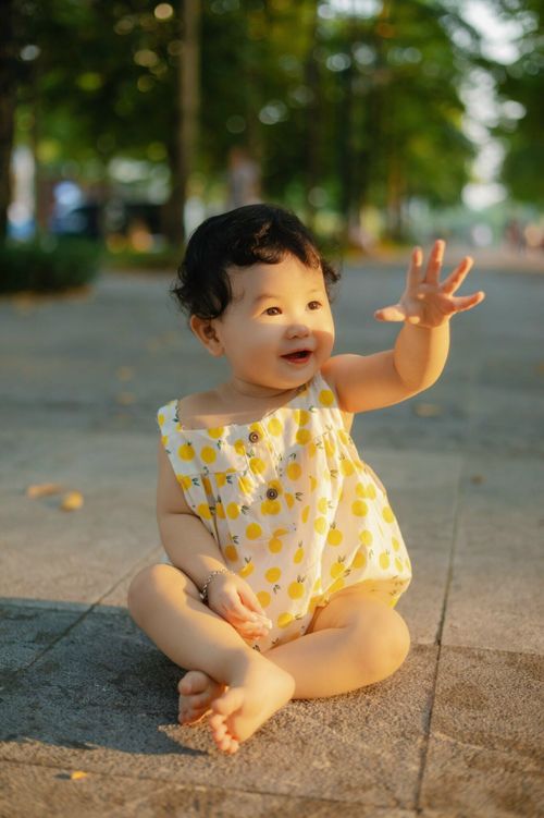 Free Cute baby enjoying a sunny day sitting in an urban park in Bắc Giang, Vietnam. Stock Photo