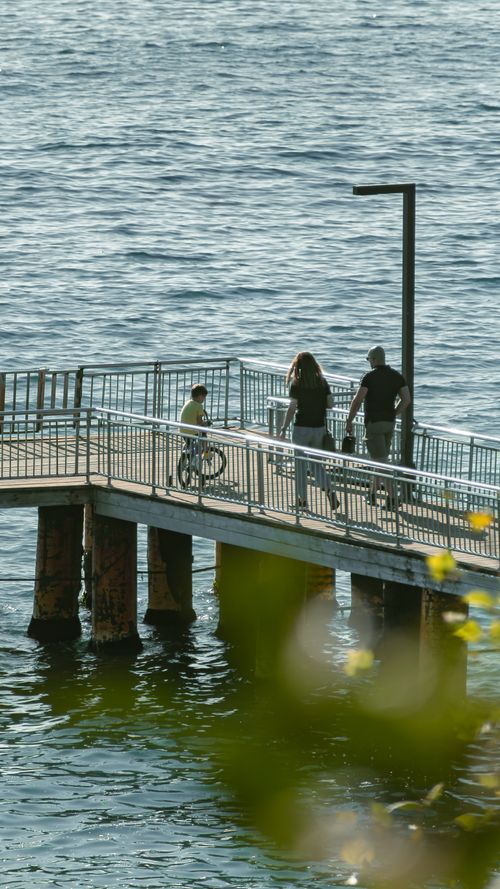 Free Family enjoying a walk on a pier by the sea in İstanbul on a sunny day. Stock Photo