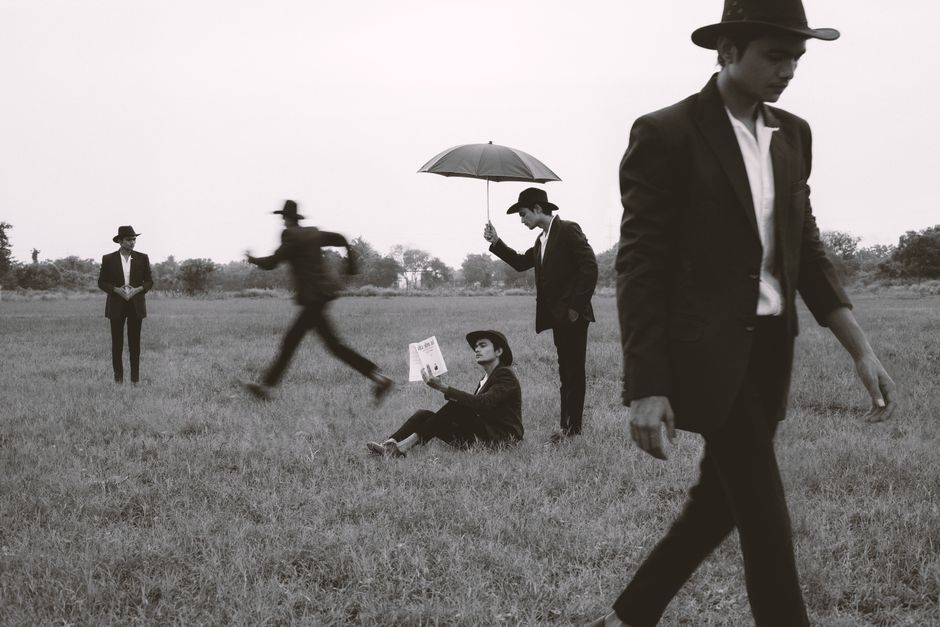 Elegant fashion concept with models in suits on grasslands in Surat, India.