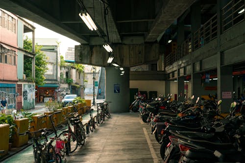 Bikes and Motorbikes Parked under Building