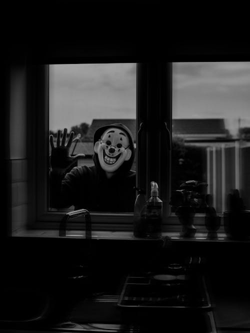 Person in Clown Mask Standing Outside Window