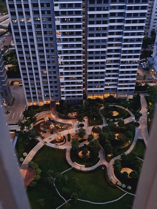 Free Aerial perspective of a modern residential complex with lush green spaces and paths at twilight. Stock Photo