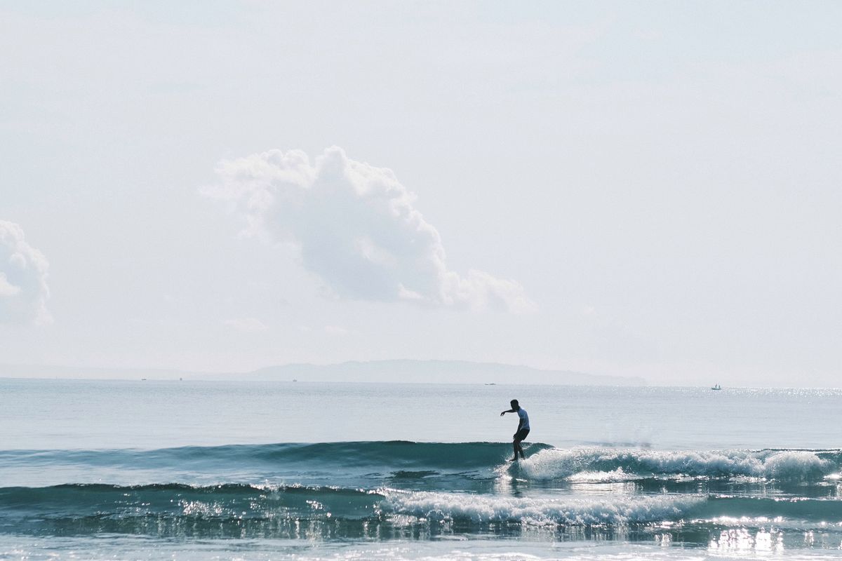 Surfista al amanecer en olas suaves