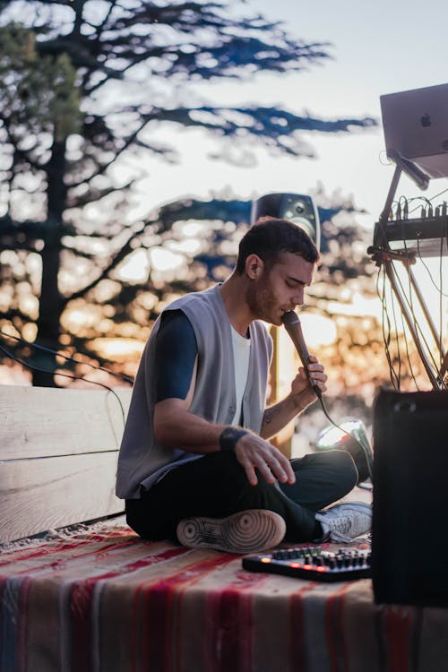 Man Sitting and Speaking to Microphone