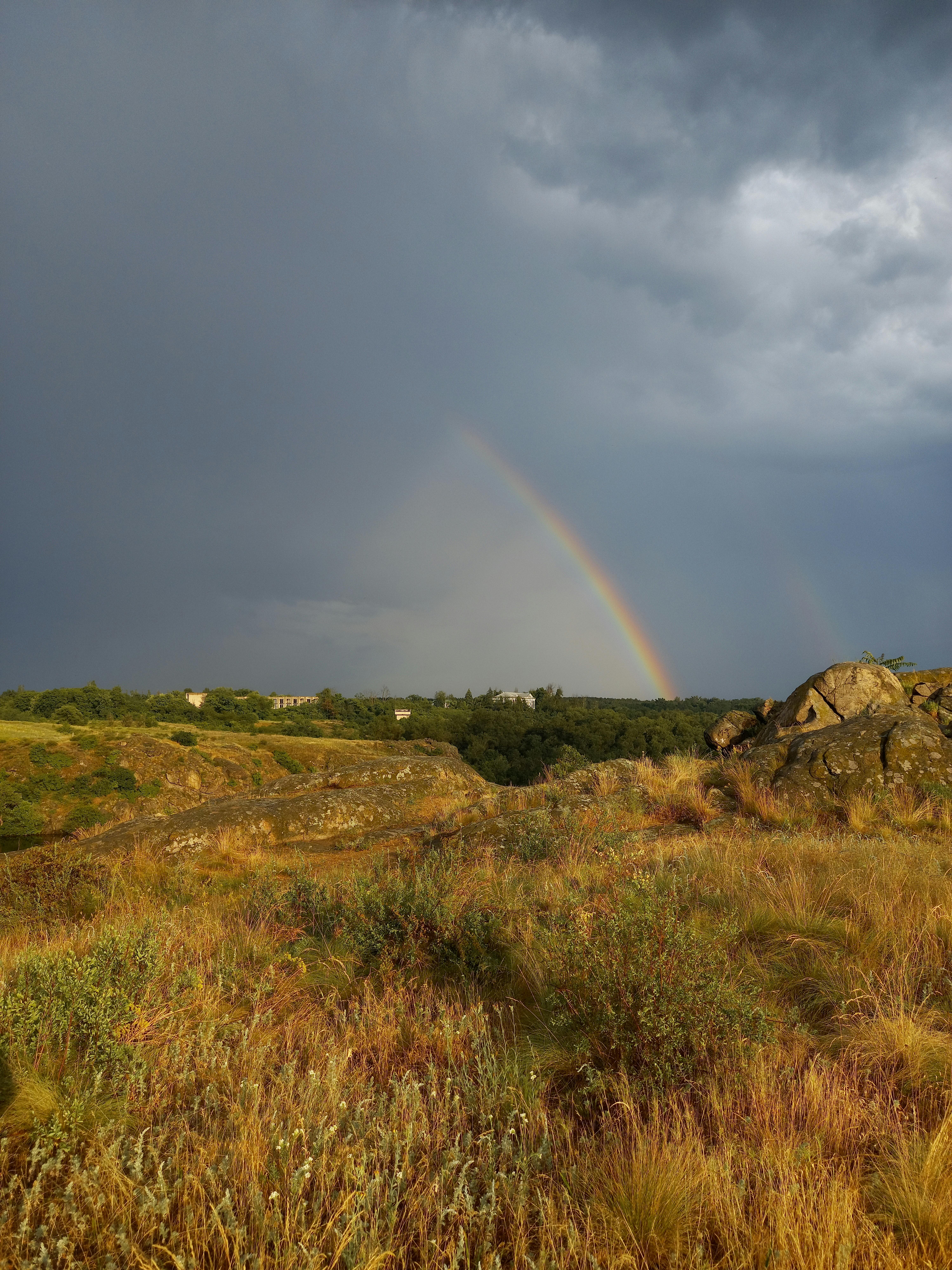 Rainbow and Rain Clouds over Grassland · Free Stock Photo