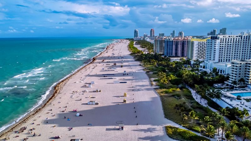 Aerial view of a South Florida beach coastline with hotels and palm trees