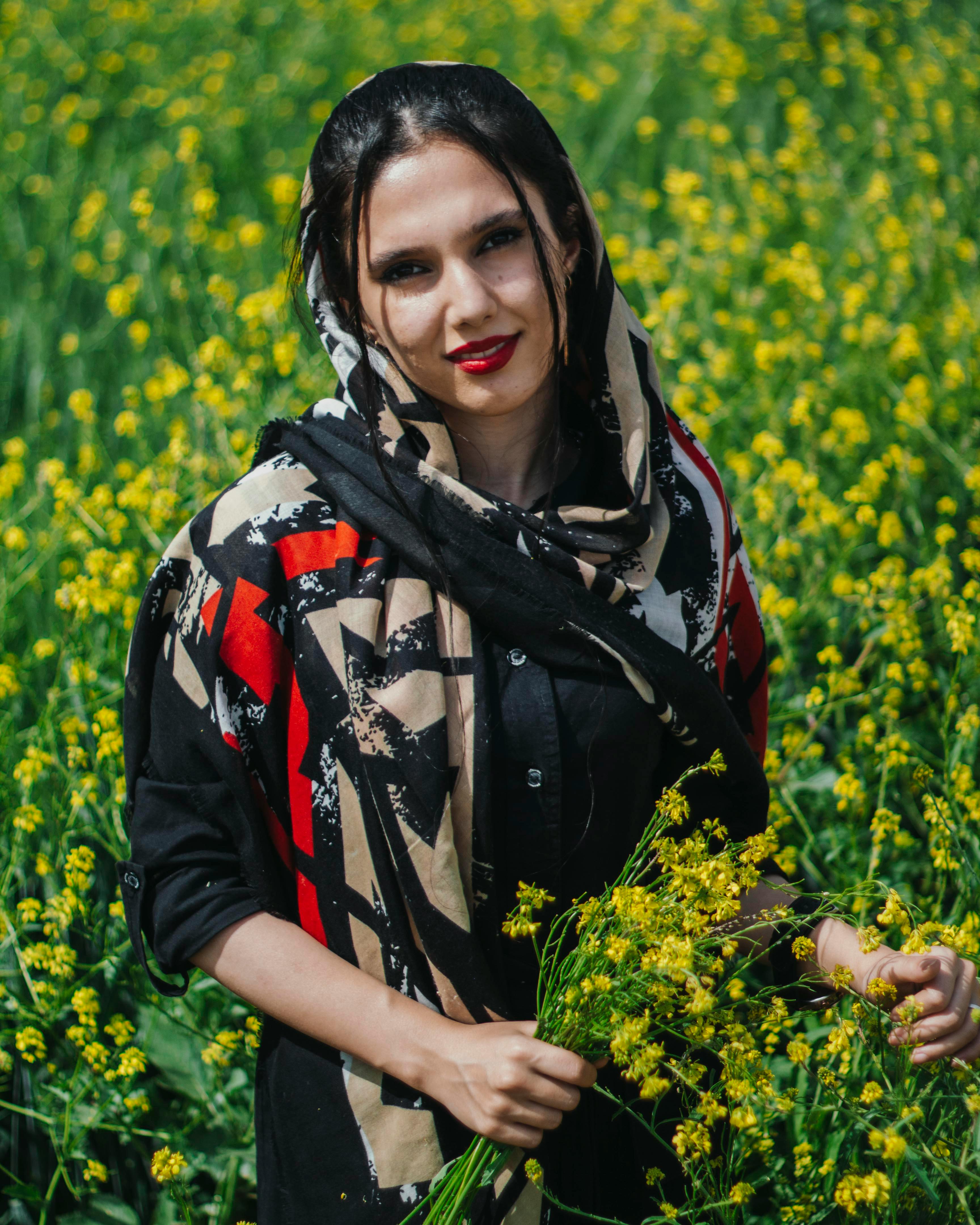 beautiful woman in headscarf and dress posing in field