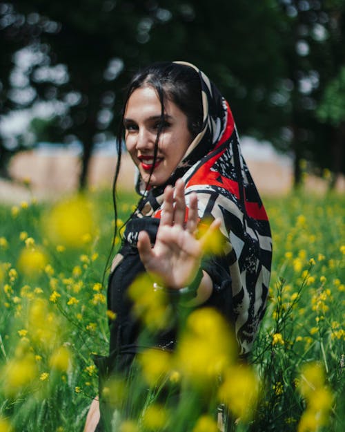Smiling Woman in Shawl Standing on Meadow