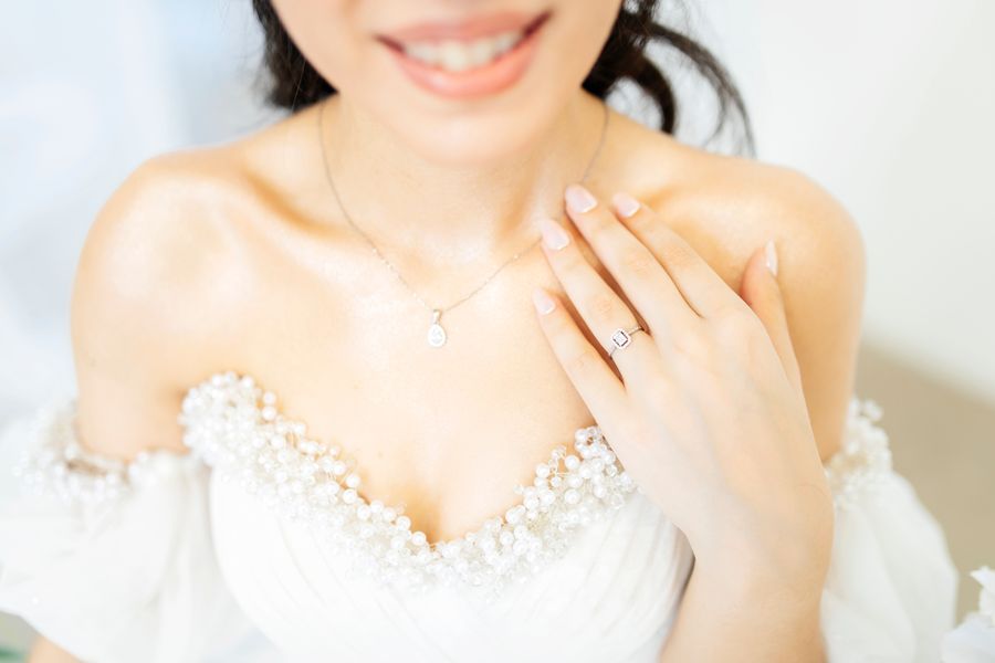 Bride's necklace and ring over a strapless wedding dress