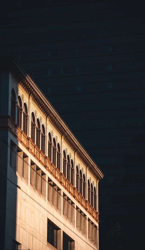 Free Architectural detail of a sunlit urban building facade with classic design elements. Stock Photo