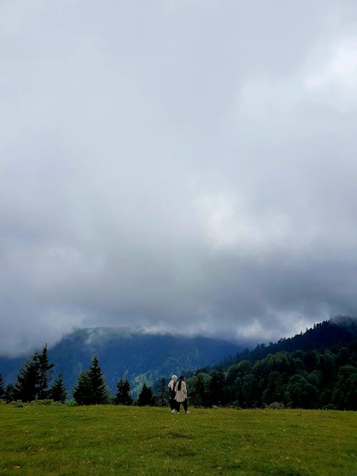 Women Walking on Grassland under Cloud