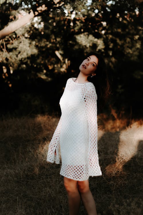 Model Posing in White Clothes near Trees