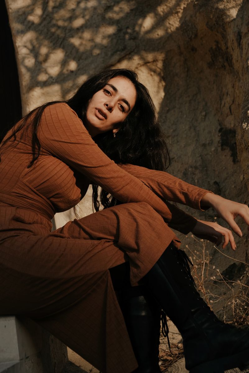 Model in brown pencil dress and knee-high boots