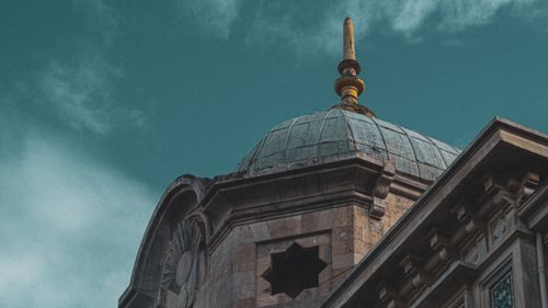 Free Close-up of an architectural dome with intricate stonework against a cloudy sky, showcasing architectural beauty. Stock Photo