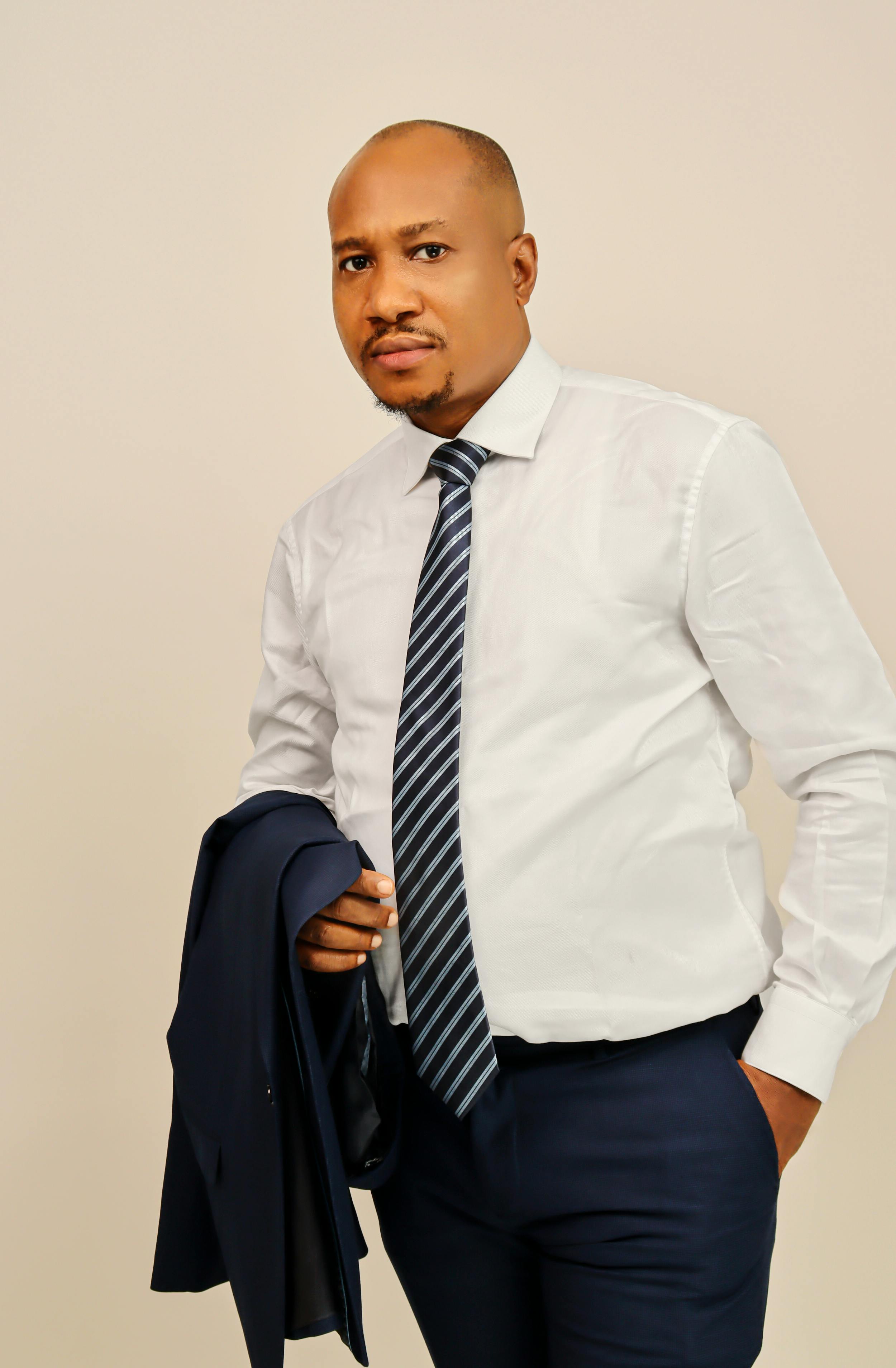 Stylish black man in formal wear posing with confidence, a must-have for business themes.