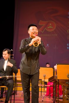 Musicians perform on stage with traditional Chinese instruments during a vibrant cultural concert.