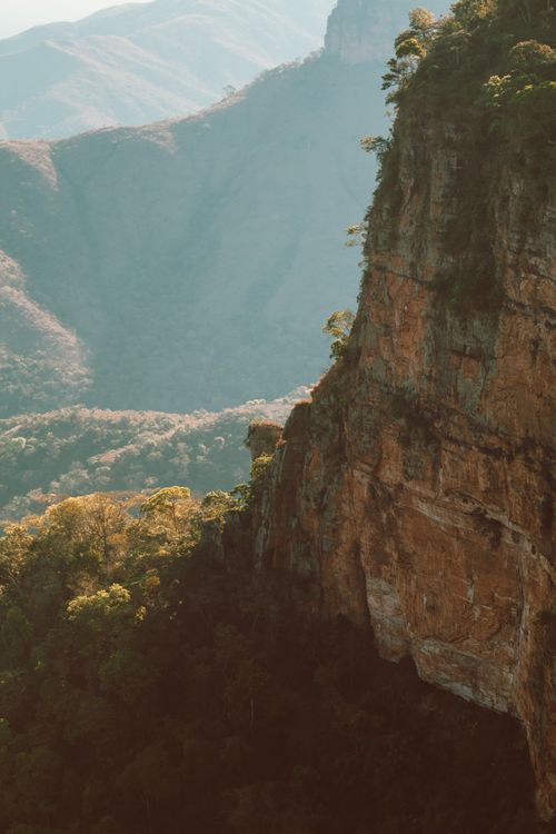Free A scenic view of towering rock formations and lush forest in Brazil, framed by mist and mountains. Stock Photo