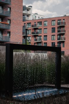 High-rise brick apartments with a decorative water feature indoors.