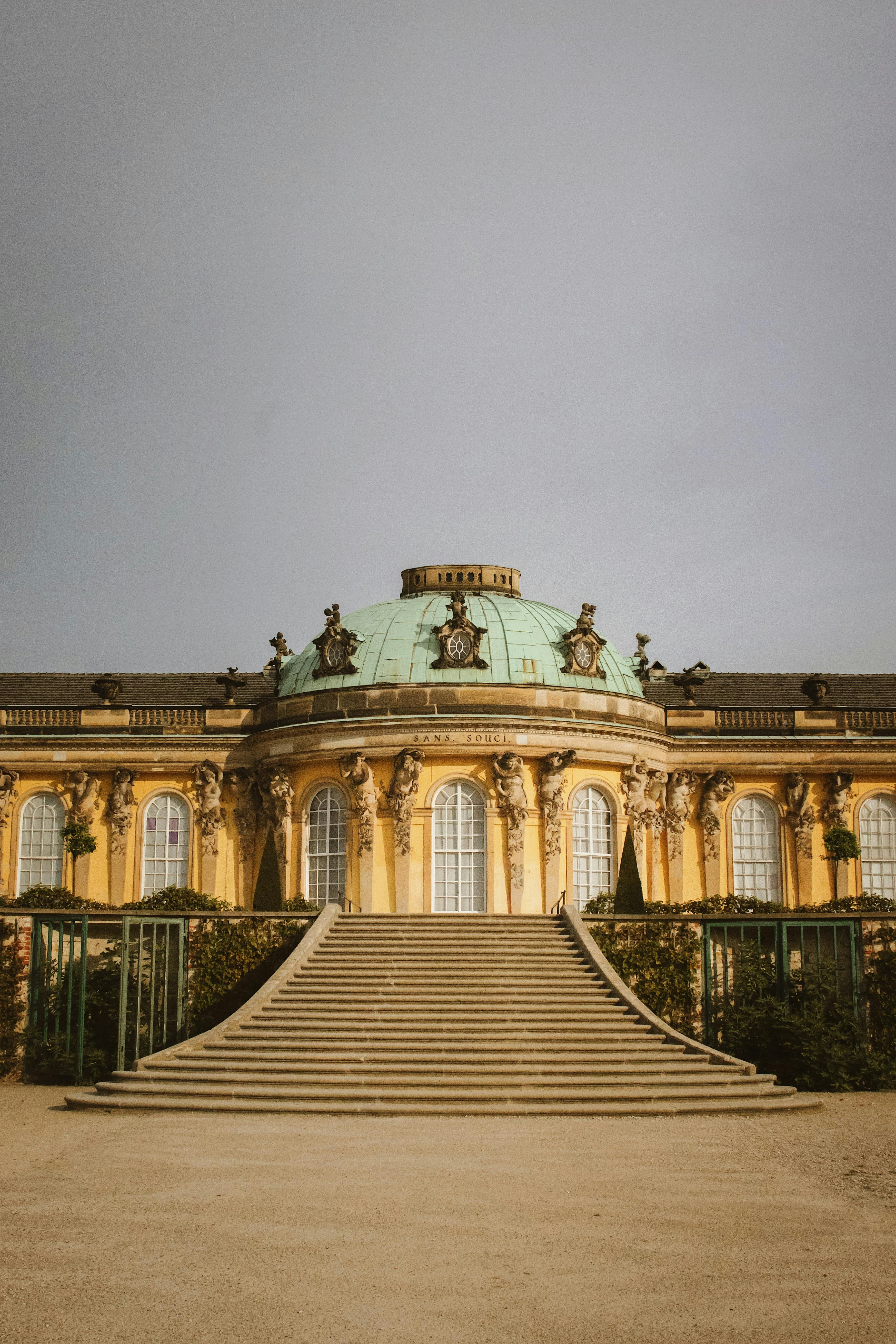 a large building with stairs and a statue