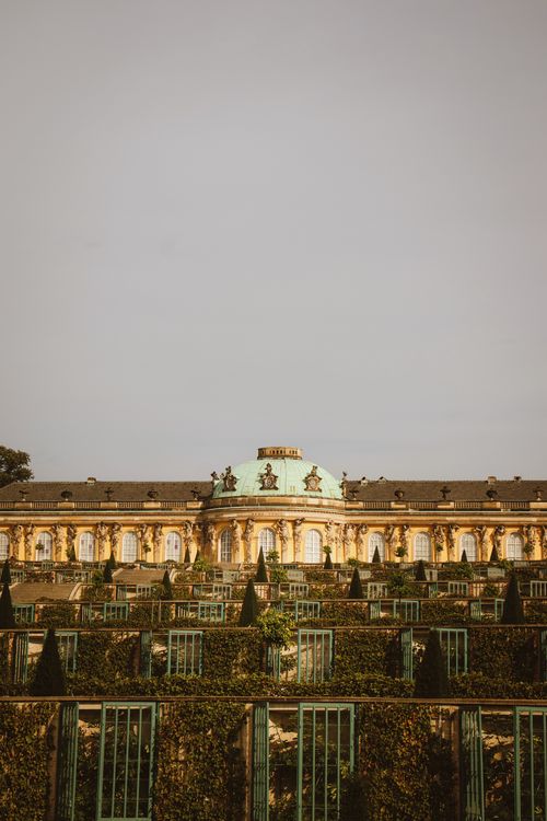 Free A serene view of the Sanssouci Palace in Potsdam, Germany featuring lush gardens in the foreground. Stock Photo
