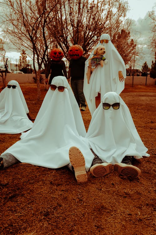 People Dressed as Ghosts Posing Outside 