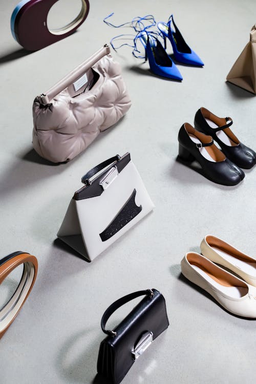 Elegant Shoes and Bags Standing on White Surface 