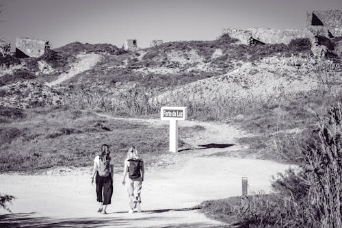 Women Hiking on Dirt Road in Black and White