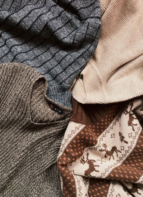 Free Collection of various textured knitted sweaters in warm brown and beige tones, perfect for winter fashion. Stock Photo