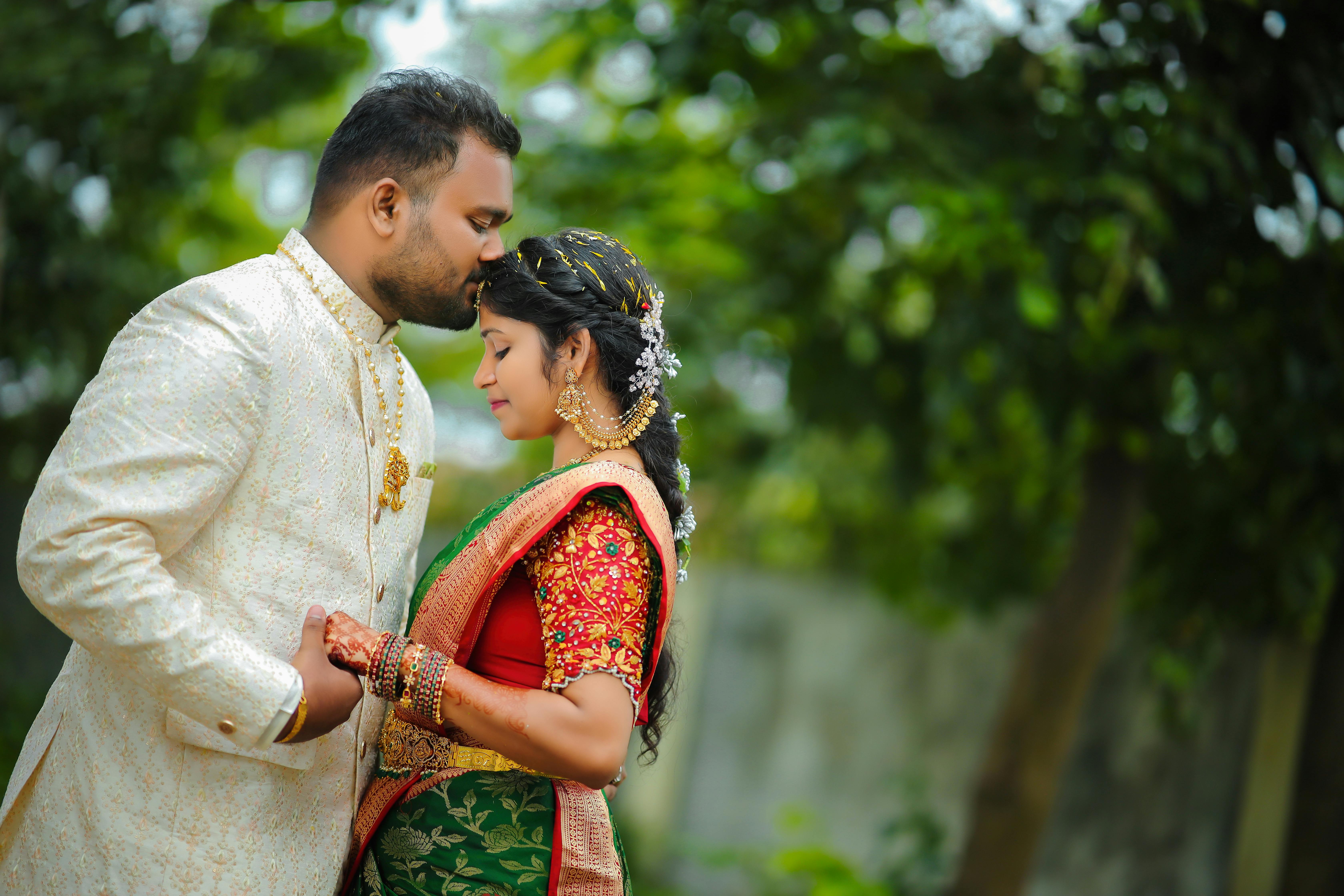 Bride and groom in affectionate embrace during a traditional Indian wedding.