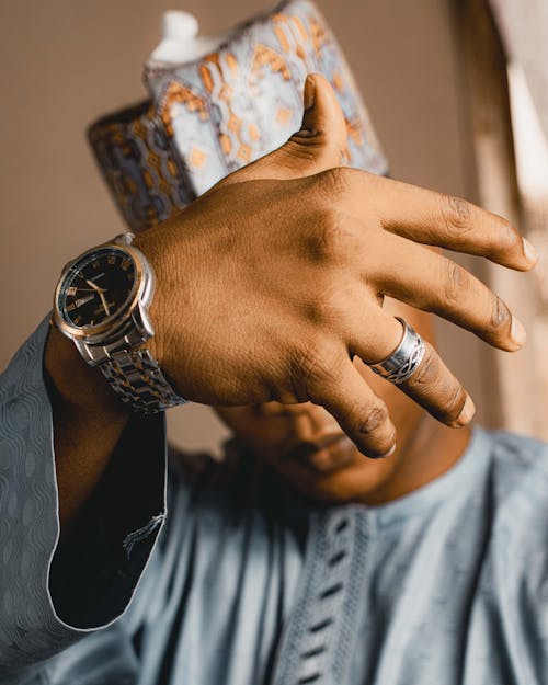 Man in Traditional Clothing Showing His Wristwatch