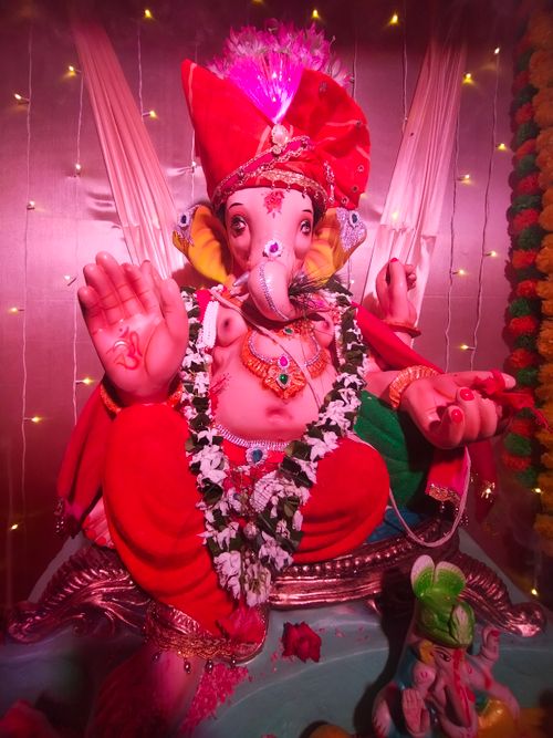 Free Colorful statue of Lord Ganesha decorated with flowers and lights, showcasing cultural festivities. Stock Photo