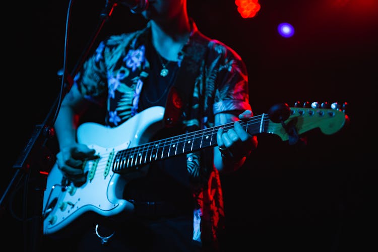 Person Singing While Playing Electric Guitar