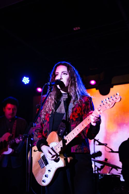 Free A captivating scene of a female guitarist and band performing live on stage. Stock Photo