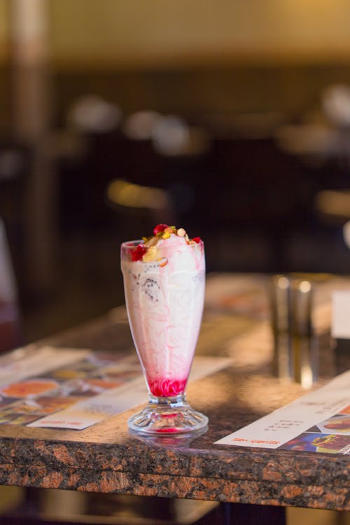 A Milkshake with Fruits Standing on a Table 