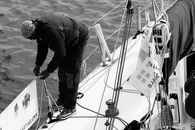 Man in Black Gray Jacket on a Boat's Railing