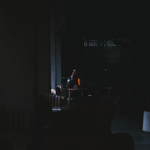 Man Smoking in Dark Cafe