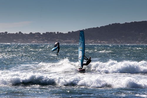 Wing Foiling Man Racing with a Windsurfer