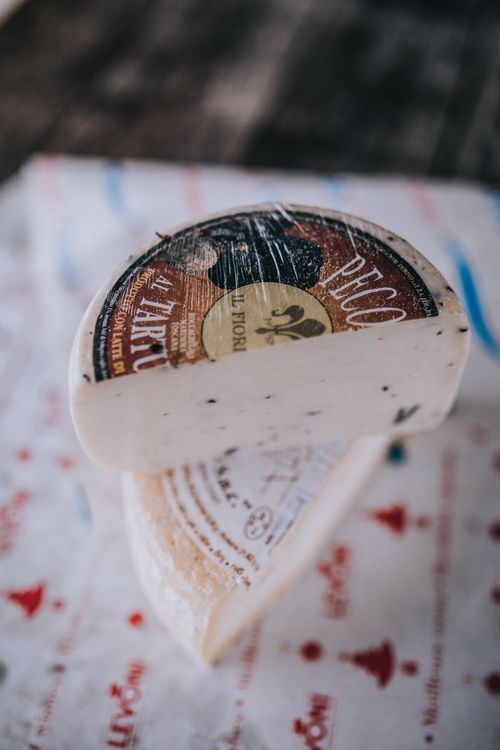 Free A detailed photo of artisan cheese slices on decorative foil, showcasing texture and branding. Stock Photo